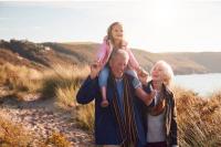 Un grand-père porte sa petite-fille sur les épaules à côté de sa femme. 