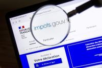 Vue partielle de l’écran du site officiel du gouvernement impots.gouv.fr avec une loupe au premier plan sur les mots impots.gouv