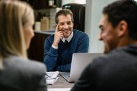 Un homme discute avec un couple assis en face de lui