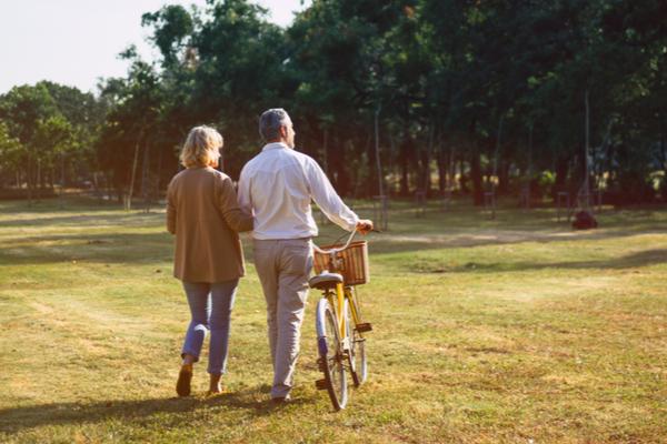 Un homme et une femme marchent à côté d'un vélo