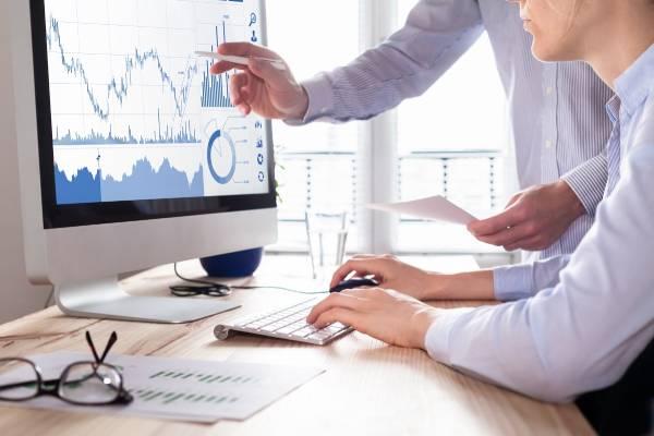 Un homme assis à un bureau regarde les marchés financiers