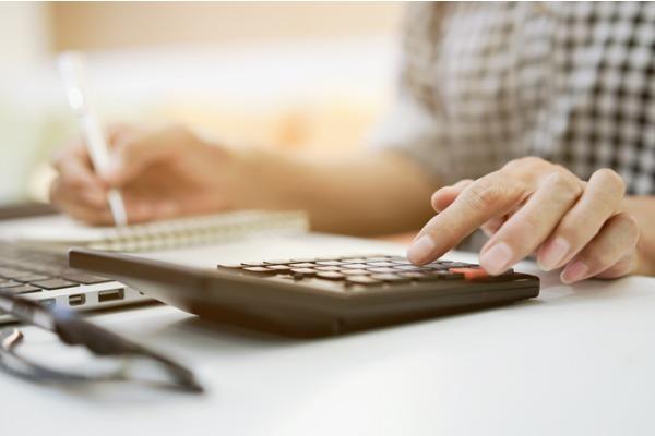 femme qui tape sur une calculatrice 