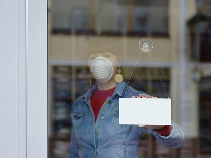 Une femme indique la fermeture de son magasin