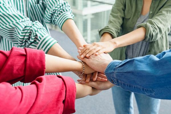 Entraide entre des personnes formant un cercle en posant leurs mains